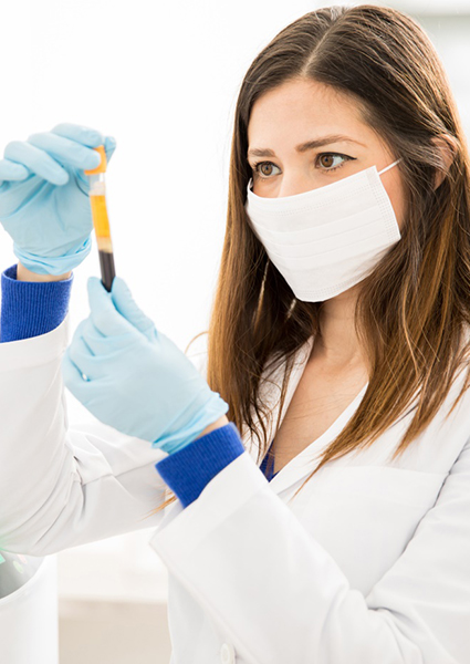 Medical team member standing beside centrifuge and holding vial of blood