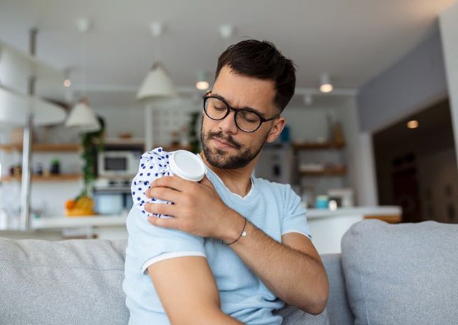 Man applying ice pack to his shoulder