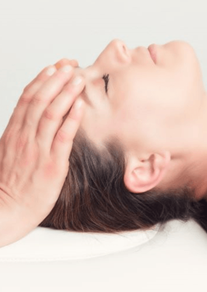 Doctor’s hands on patient’s head during cranial osteopathy session