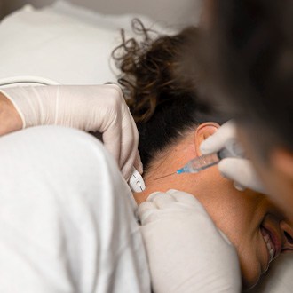 Doctor administering an interventional spine injection into the knee