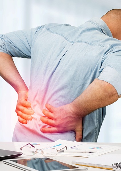 Man with lower back pain, may benefit from prolotherapy