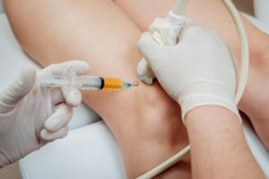 Doctor using ultrasound guidance to administer injection