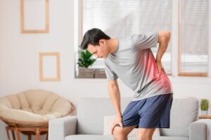 Man struggling to stand up due to back pain