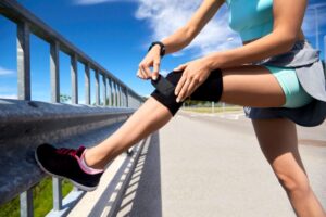 Female athlete wrapping a brace around her knee