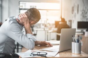 Man sitting at computer, dealing with neck pain